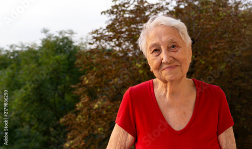 Portrait of old senior woman at balcony