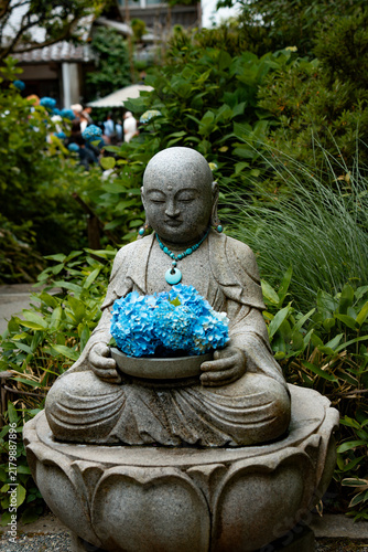 statue of a buddha wit blue hydrangea 