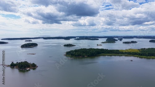 Aerial view of the Finnish archipelago in the Gulf of Finland, Baltic Sea, showing scattered forested islands surrounded by calm grey waters under dramatic cloudy sky