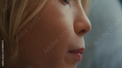 Profile view of a child concentrating while reading a storybook, his lips moving as he follows the words