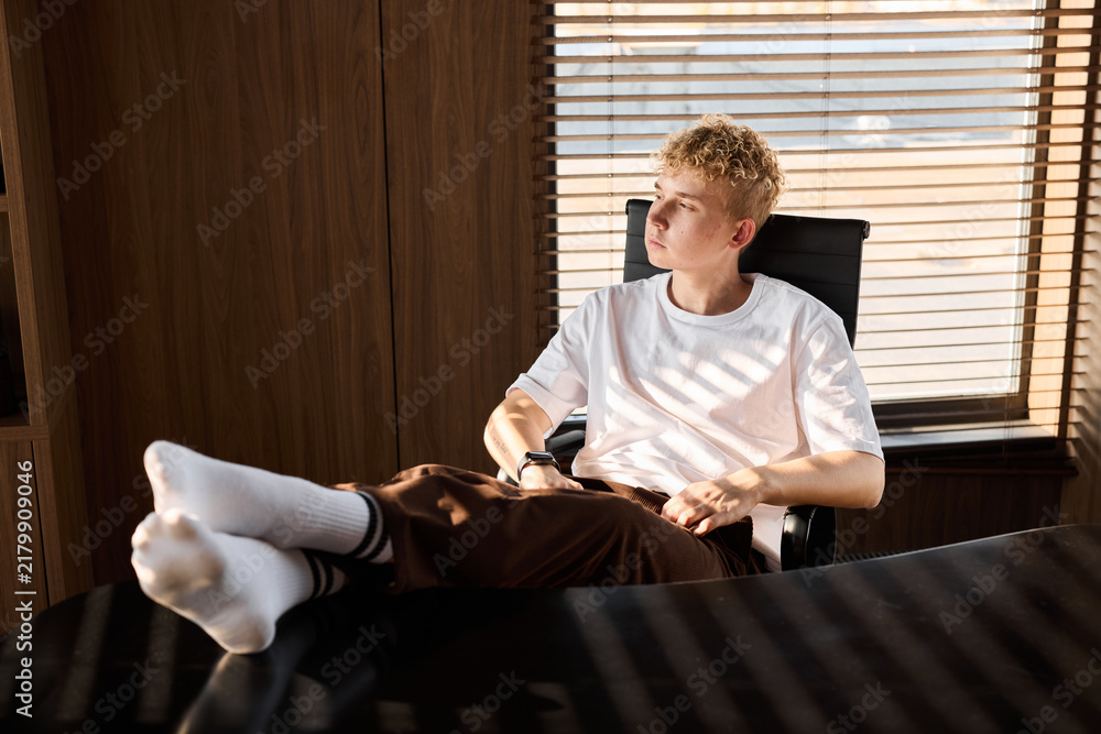 Fototapeta premium Serene individual at ease in cozy home office during golden hour