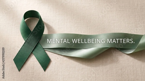Green Ribbon Mental Health Awareness Symbol with Mental Wellbeing Matters Quote on Textured Background for Healthcare.