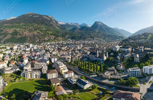 Fotografie Aerial drone panoramic cityscape view of historic Brig town with Stockalper Palace and the Alps in Valais, Switzerland