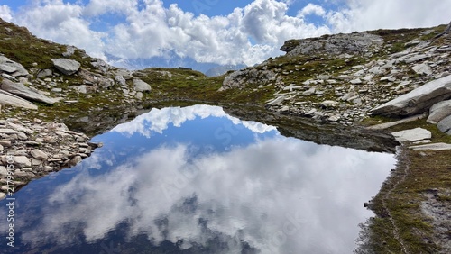 Foto Mountain landscape with a reflecting pond under a cloudy sky in Switzerland