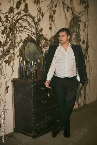 Canvas Print Suited individual with cigarette appears contemplative in dim setting