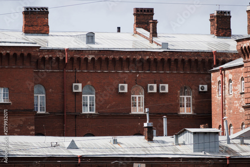 Historic red brick building with modern AC units and roof. High quality photo.