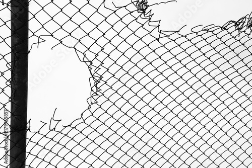 Fotografie Opening in metallic fence isolated on white sky background Challenge