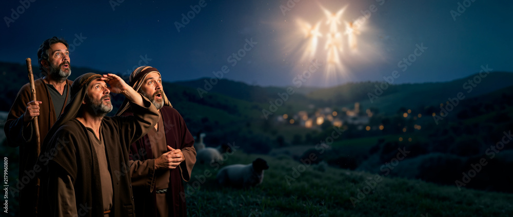 Fototapeta premium Biblical shepherds looking up in awe at glowing angels in the night sky. Annunciation to the shepherds nativity scene banner. Christian Christmas story concept