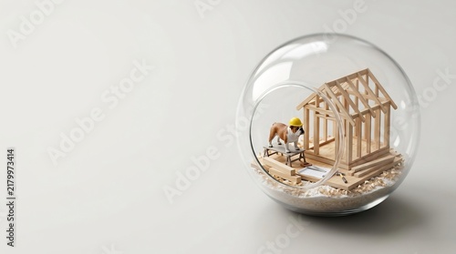 Bulldog in a hard hat constructing a miniature wooden house frame inside a glass terrarium. Concept of home building, real estate, labor, and craftsmanship on a clean background.