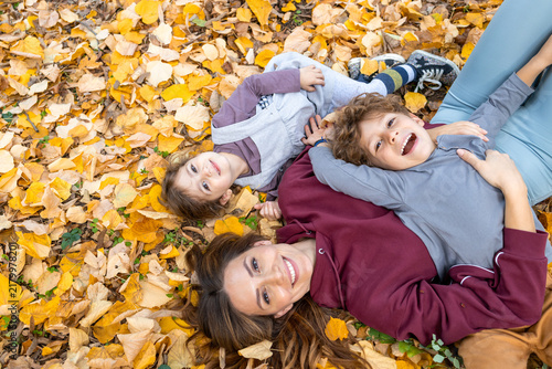 Canvastavla Family enjoying autumn leaves together, a mother and her two children lying down