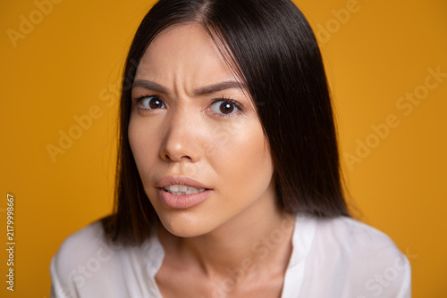 фотографія Skeptical woman looking suspiciously at camera close up