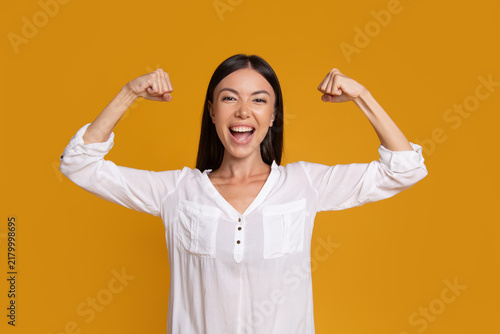 Happy confident woman flexing arms to show strength