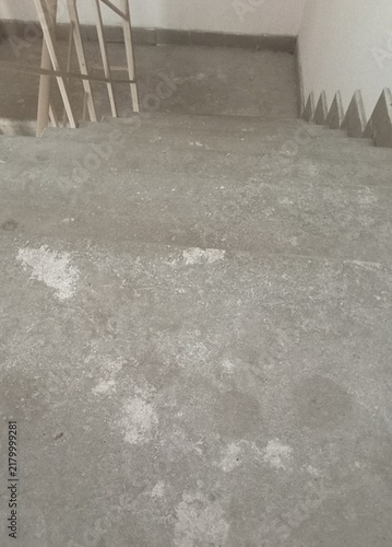A view looking down a set of unfinished concrete stairs in a modern building construction project