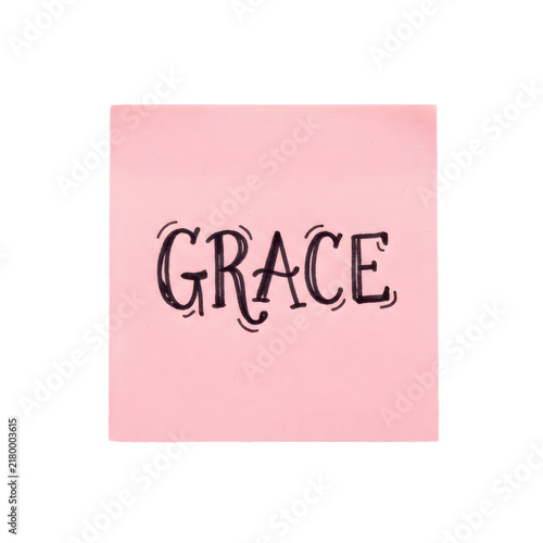 Pink adhesive note with the word grace written in hand lettered black ink script