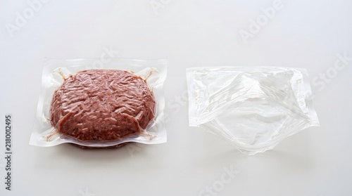 Sealed vacuum packed meat sample beside empty package, cultivated meat product packaging concept