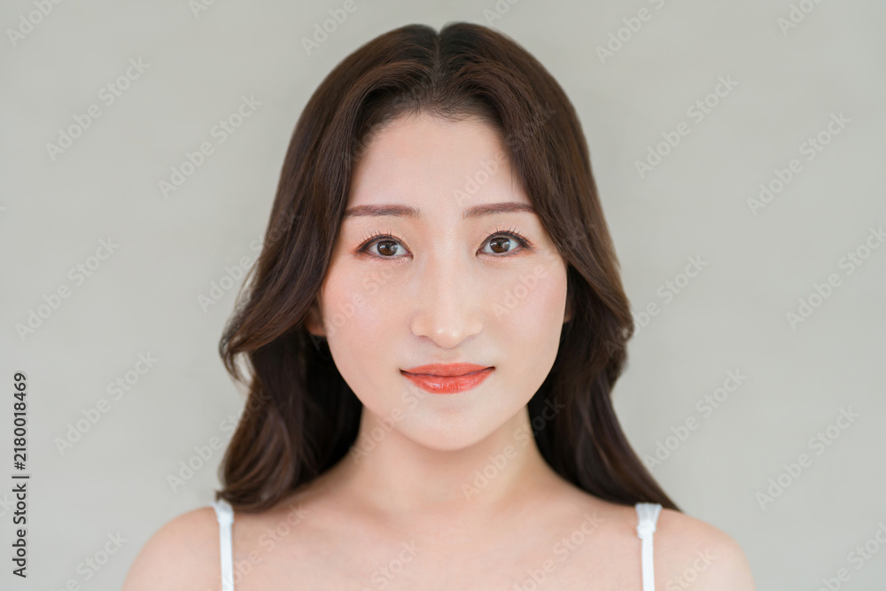 Fototapeta premium Beauty portrait of a woman (in her 40s or 50s) with clear, radiant skin gazing straight ahead.