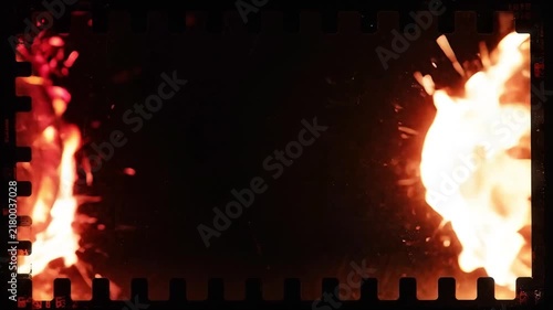 Burning celluloid film strip caught on fire with sparks flying on transparent background
