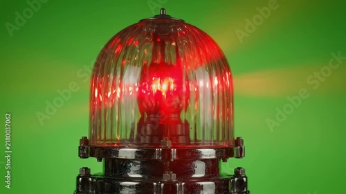 Rotating red warning beacon light on green background with light casting on transparent background