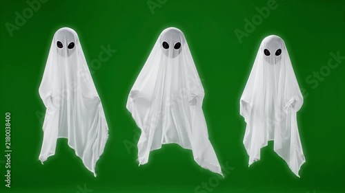 Multiple white ghosts moving and floating against a green background on transparent background