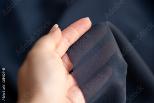 mano sosteniendo tela vaporosa color azul con transparencia