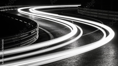Dynamic long exposure light trails on winding road at night
