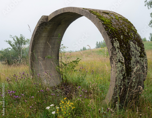 Weathered concrete ring structure in grassy field