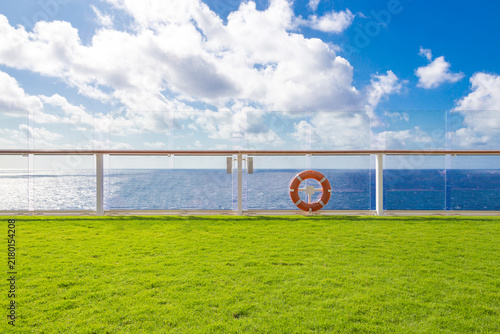Bild auf Leinwand Orange lifebuoy on a deck of cruise ship with ocean on background with blue sky
