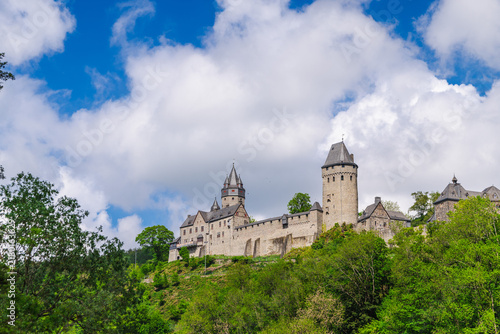 Quadro su tela Stone Castle Towers Above Wooded Hillside and Clouds