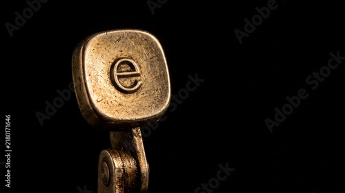 Vintage typewriter key letter e in close up macro shot with dark background
