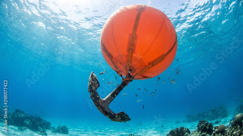 Staying Afloat in Crisis Concept Massive Orange Inflatable Balloon Pulling Heavy Anchor Upwards Underwater