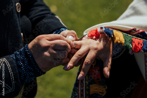 Photography Close-up of hands during a wedding ring exchange, with one person placing a deco