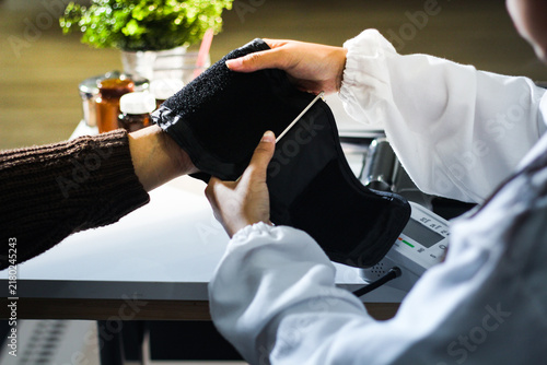 Foto A doctor's hands carefully taking a patient's blood pressure using a sphygmomanometer