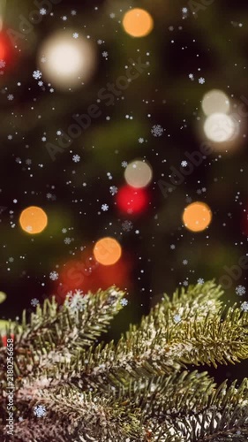 Animation of snowflakes over bauble decoration against blurred view of christmas tree at home