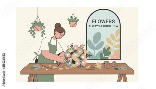 Creative female florist in an apron arranging a beautiful colorful bouquet of flowers at a wooden work table.
