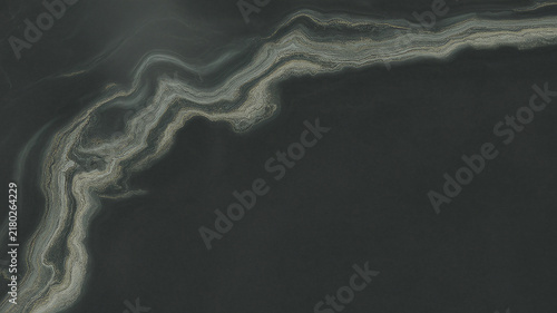 Winding geological formation with layered sediment is displayed in dark tones