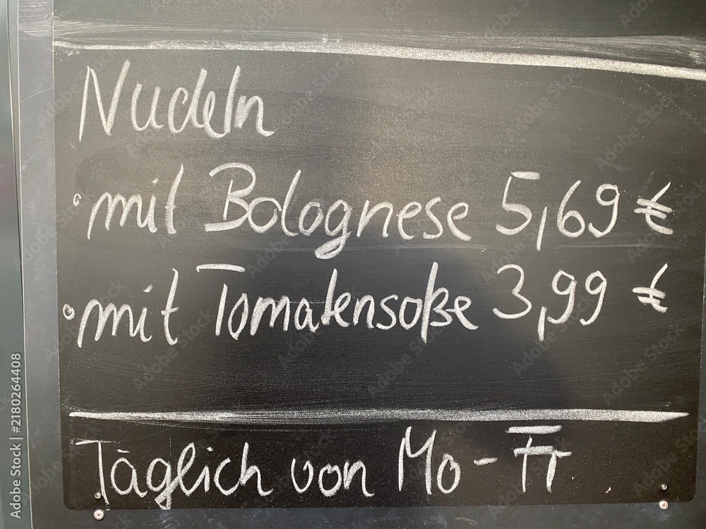 Fototapeta premium Handgeschriebene Kreidetafel mit Imbissangeboten wie Bratwurst, Bockwurst, Boulette und Grillkäse samt Preisen. Street Food, Speisekarte, Snack, Gastronomie und deutscher Imbiss.
