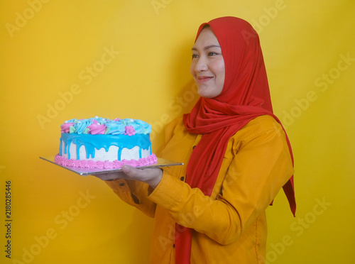 Side View Of Adult Asian Woman In Hijab Giving Birthday Icing Cake To Someone