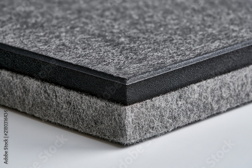 Gray felt acoustic panel stacked in close-up on white surface  