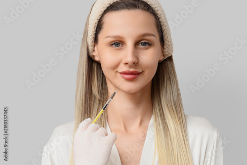 Fotografie Cosmetic procedure and lip filler injection, woman receiving facial aesthetic tr
