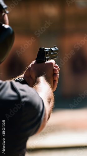 A man aiming an air pistol at an outdoor shooting range for enjoyment and amusement, target shooting drills, and marksmanship instruction