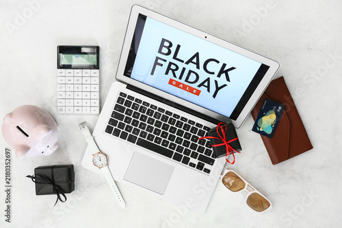 Laptop with text BLACK FRIDAY SALE, wallet, piggy bank and accessories on lig...