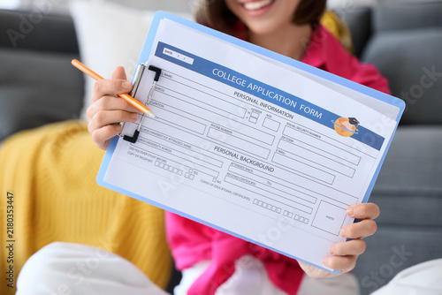 Teenage girl with college application form at home, closeup