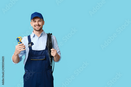Foto Portrait of male electrician with crimper and wires on blue background