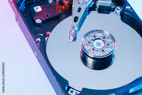 opened computer hard disk drive HDD internal components focusing on plattered disk and actuator read write head arm as a conceptual metaphor for cyber security big data cloud computing infrastructure