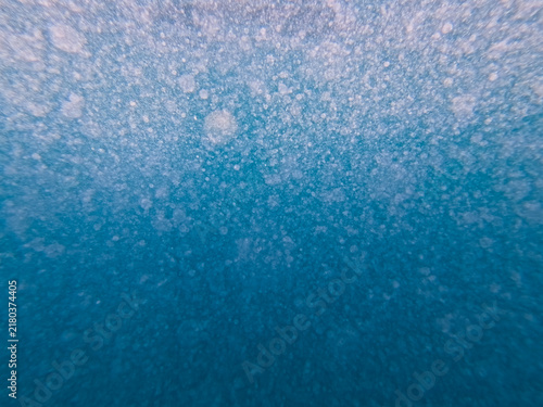 Foto Abstract underwater background filled with countless tiny air bubbles and foam particles floating in the deep blue waters of the Mediterranean Sea