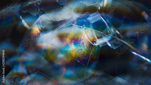 Iridescent soap bubble cluster showing abstract fluid patterns