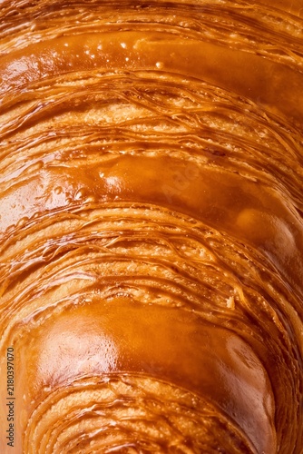 Flaky crispy croissant close up with great texture. All in focus, full frame