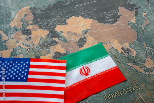Iran and USA national flags on the paper world map. Iran and USA conflict.