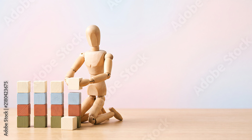 Marketing team KPI tracking and business growth building concept with wooden mannequin stacking block bar chart with copy space for performance review presentation banner