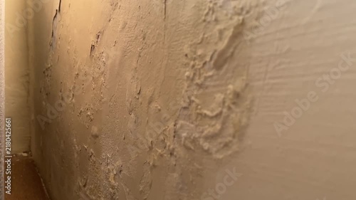 Panning shot of wall paint blistering and bubbling from moisture